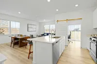 Open concept floor plan with kitchen island next to office with barn door