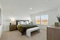 Townhomes in Brownsburg, IN, with In-Unit Washer and Dryer - Wynne Farms - Bedroom With Green Throw Blanket, White Bench, Wood Nightstands, And Two Large Windows.