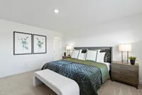 Furnished main bedroom with carpet
