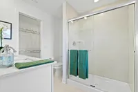 Main bathroom with walk in shower next to walk in closet