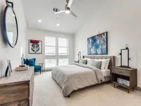 Main bedroom with large bed and carpet and tall ceilings
