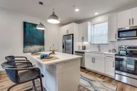 Upscale kitchen with white cabinetry and stainless steel appliances