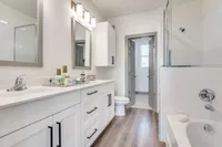 brightly lit bathroom with standing shower connected soaking tub