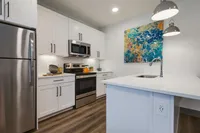 Decorated modern kitchen with stainless stee appliances and white cabinetry
