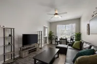 Model living room with black couch and tv