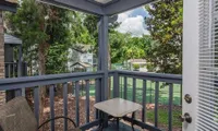 view of private patio/balcony overlooking tennis court