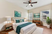 Townhomes with attached Garage in North Austin, TX - Lone Oak Homes - Bright Bedroom With Upholstered Bed, Nightstands With Lamps, Dresser, Ceiling Fan, And Wide Windows With Blinds.