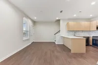 Kitchen with light wood cabinets and living room space