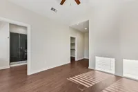 Bedroom with ceiling fan and primary bathroom