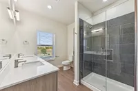 bathroom with double vanity, stand up shower