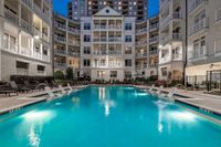 Swimming pool with sundeck and lounge chairs at dusk