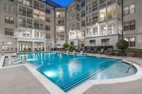 Swimming pool with sundeck and lounge chairs at dusk