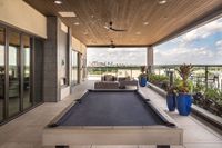 Luxurious rooftop terrace with a pool table, comfortable seating, and panoramic cityscape views, perfect for entertainment and relaxation.