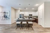 Modern kitchen with sleek bar seating, stainless steel appliances, and elegant pendant lighting, perfect for entertaining.