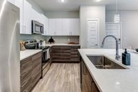 Modern kitchen with sleek stainless steel appliances, elegant white cabinetry, and a stylish island with a built-in sink.