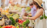 woman picking up garlic at farmers market
