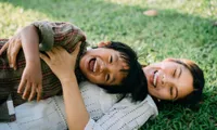 woman and child lying on grass outside