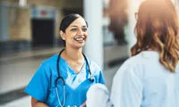 two women talking with one woman in nurse's outfit with stethoscope