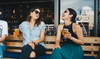 two women drinking beer at bar