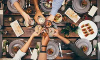 people toasting over food at restaurant