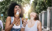 Two girls eating ice cream and laughing