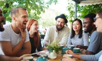 Group of friends conversing on a restaurant patio