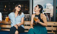 Two girls enjoying a beer outdoors