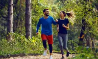 man and woman jogging on trail