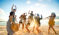 group of people jumping in air at beach