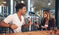 guy and girl toasting a beer at a brewery