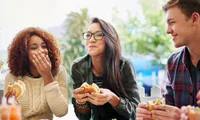 group of friends eating burgers outdoors