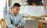 MAn working on computer at coffee shop