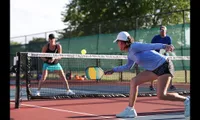 Players engaged in an intense pickleball match on an outdoor court.