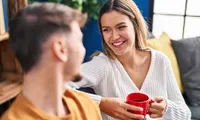 A warm and inviting living room scene with two people enjoying each other's company over coffee.