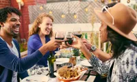 group of friends outdoor dining and toasting a glass of wine