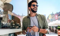 man shopping outdoors holding a phone