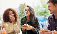 group of friends eating burgers outdoors