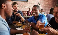 Middle age men eating and drinking at a restaurant