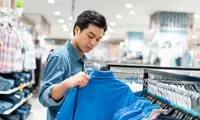 man shopping for a shirt at a store