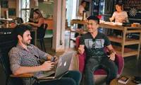 two men working on laptops at a coffee shop