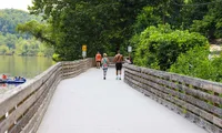 people walking along dock next to river