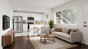 Modern open concept living space with sleek kitchen, cozy seating area, and abundant natural light.