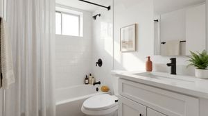 Modern bathroom with sleek design, featuring a white bathtub, stylish black fixtures, and a refreshing potted plant on the vanity.