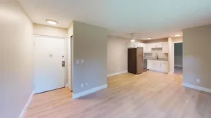 Bright open kitchen with white cabinets, modern appliances, and expansive hardwood flooring.