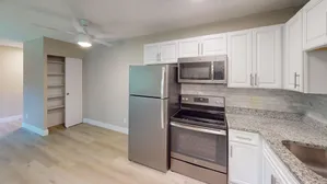 Stylish kitchen with stainless steel appliances, granite countertops, and white cabinetry.
