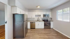 Modern kitchen with sleek stainless steel appliances, elegant granite countertops, and white cabinetry.