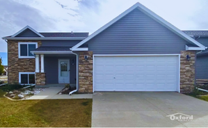 Modern suburban home with stone accents and a large garage, offering a welcoming and stylish façade.