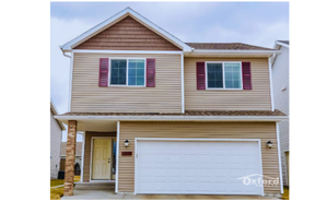 Charming two-story home with a spacious garage, featuring a welcoming entrance and stylish exterior with brick and siding accents.
