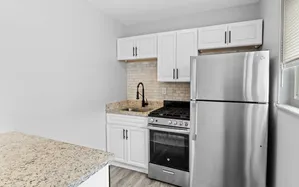 Modern kitchen with sleek stainless steel appliances, granite countertops, and elegant white cabinetry.