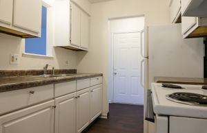 Modern kitchen featuring elegant white cabinetry, sleek countertops, and efficient appliances, perfect for culinary adventures.